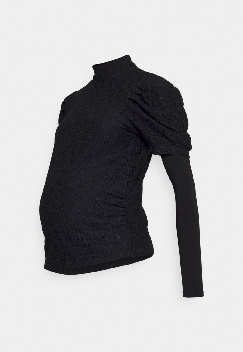 Top de maternidade preto com mangas curtas e bufantes, gola alta e padrão texturizado. O design ajustado acomoda uma barriga em crescimento.