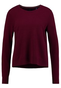 Maglione bordeaux con maniche lunghe, scollo rotondo e un orlo leggermente accorciato. Realizzato in materiale morbido e strutturato con dettagli a costine.