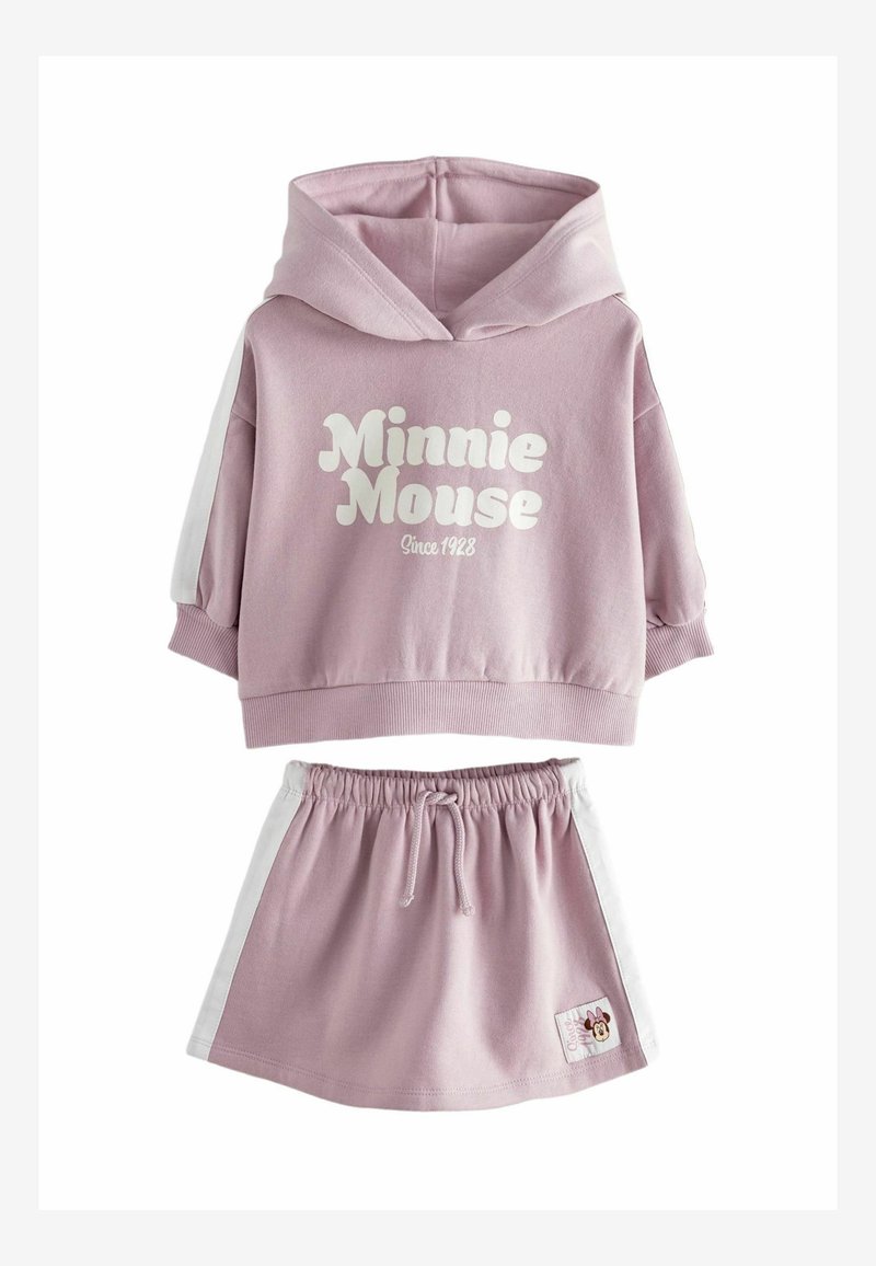 Heled roosa kapuutsiga särk, millel on kiri "Minnie Mouse Since 1928" ja lühikesed varrukad, koos sobiva seeliku kõrgete valgete ääriste ja logo plaastriga.