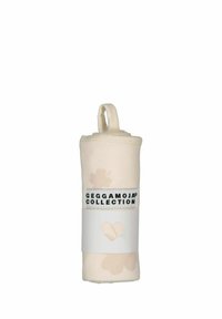 Rullad ljusbeige tygartikel med blommönster och en ögla för upphängning. Har en svart etikett med texten "GEGGAMOJA KOLLEKTION."