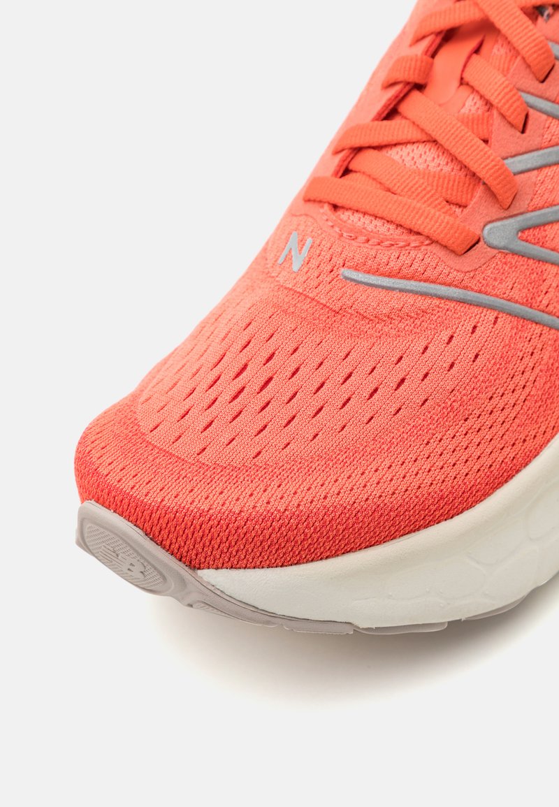 Korallenfarbene Mesh-Laufschuhe mit strukturierter Oberfläche, verstärkter Zehenkappe und grauen Akzenten. Bietet ein Schnürdesign und eine konturierte weiße Zwischensohle.