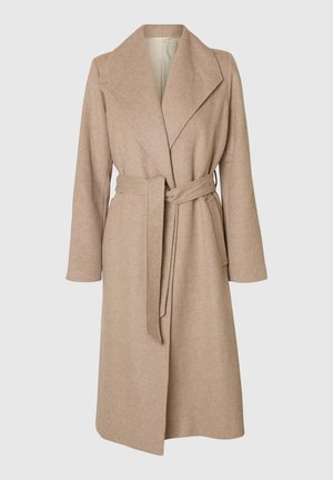 Un long manteau en laine beige avec de larges revers, une taille ceinturée et des poches latérales sur fond blanc.