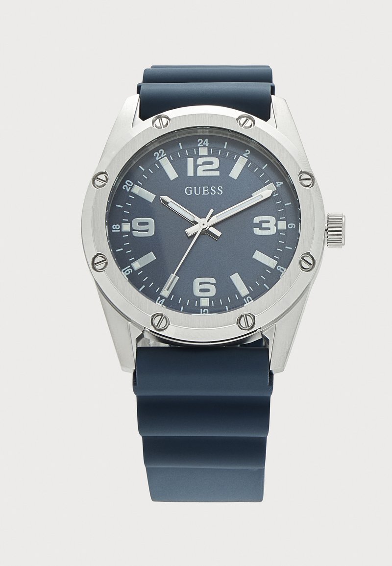 Montre-bracelet analogique avec cadran bleu, boîtier argenté, index des heures blancs et bracelet en caoutchouc bleu affichant l’heure 10:08:36.