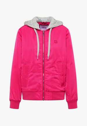 Veste bomber zippée rose vif avec capuche grise et cordons de serrage, poches latérales, poignets côtelés et logo discret sur la poitrine gauche.
