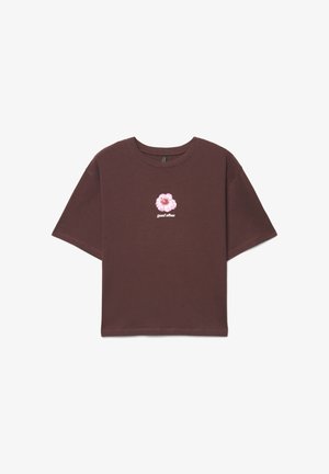 T-shirt marron à manches courtes avec un motif de fleur rose et le texte « good vibes » centré sur la poitrine.