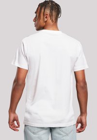 Wit T-shirt met korte mouwen en een ronde hals, gemaakt van katoen, met een effen ontwerp en een losse pasvorm. Getextureerde stof zichtbaar aan de achterkant.