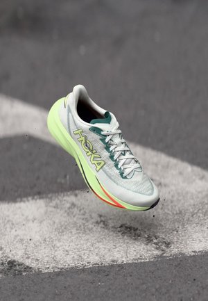 Scarpa da corsa leggera con tomaia in mesh verde menta e bianca, logo giallo brillante e suola ammortizzata con accenti rossi.