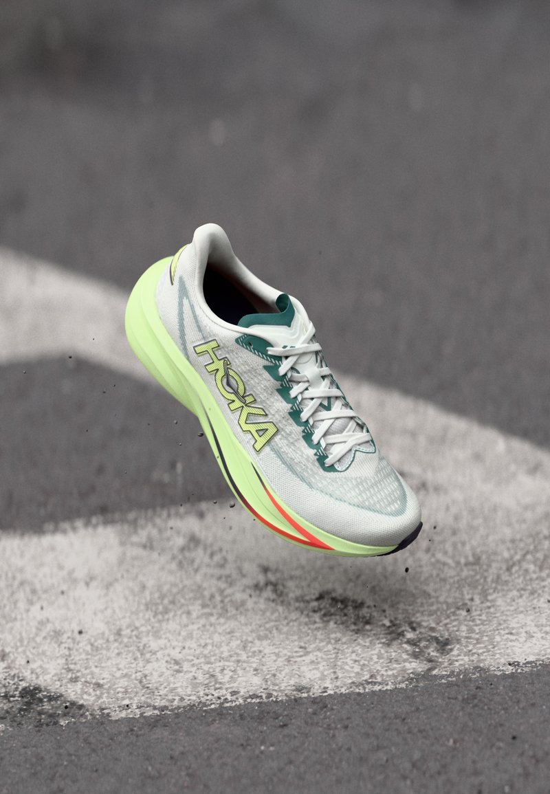 Lagana tenisica za trčanje s gornjim dijelom od mrežastog materijala u nijansama mente i bijele boje, svijetložutim logotipom te jastučićastim potplatom s crvenim detaljima.