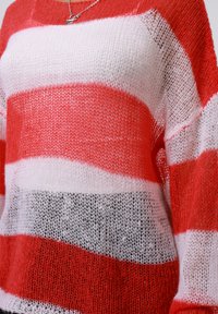 Maglione lavorato a maglia a righe rosse e bianche con una vestibilità ampia, caratterizzato da una lavorazione testurizzata e aperta. Include una striscia nera nella parte inferiore.