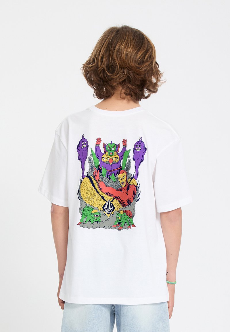 Personne portant un t-shirt blanc avec un graphisme coloré de style cartoon représentant des monstres, des créatures et de la fumée au dos.