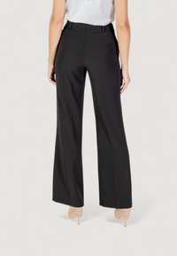 Pantaloni neri a gamba larga con una texture liscia, design a vita alta e passanti per cintura. Presentano un orlo pulito e due tasche posteriori.