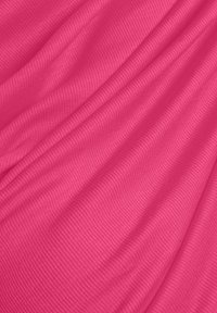 Rosa Stoff mit einer gerippten Textur, der glatte Falten und Wellen zeigt und eine lebendige, einfarbige Optik ohne Muster oder Verzierungen präsentiert.