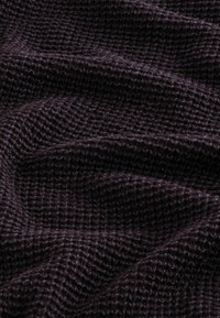 Strickstoff in Dunkelviolett, mit einem strukturierten Muster, das eine weiche, leicht fuzzy Erscheinung und verschiedene Stichstärken aufweist.