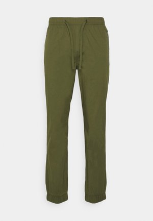 Olive green drawstring pants made of soft fabric, featuring elastic cuffs, side zip pockets, and a relaxed fit design.