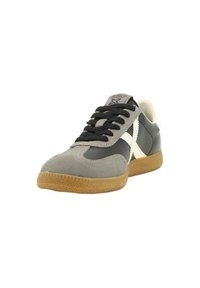 Szare i czarne buty sportowe z zamszu i skóry, okrągły czubek, białe akcenty i gumowa podeszwa. Sznurówki są czarne.