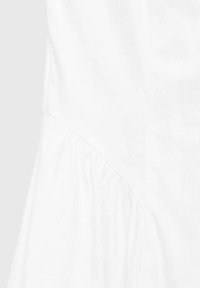 Robe en coton blanche avec un corsage ajusté et un détail froncé le long de la couture latérale. Texture lisse et design minimaliste.