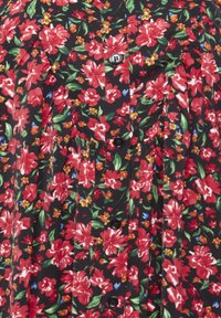 Camicia a maniche corte con bottoni, caratterizzata da uno sfondo nero con fiori rossi e foglie verdi, tessuto strutturato e bottoni neri per la chiusura.