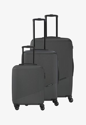 Three black hard-shell suitcases stacked together, featuring a ribbed texture, extendable handles, and four spinner wheels for easy mobility.