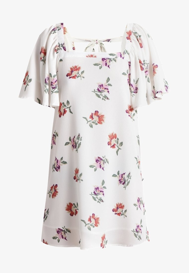 Vestido blanco floral con mangas cortas y onduladas, que presenta patrones de flores rojas, moradas y verdes por toda su superficie. Escote cuadrado con detalle de lazo en la parte posterior.