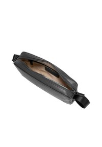 Svart läderclutch med dragkedja, slät textur och beige insida, utrustad med en sidoloop för enkel hantering.