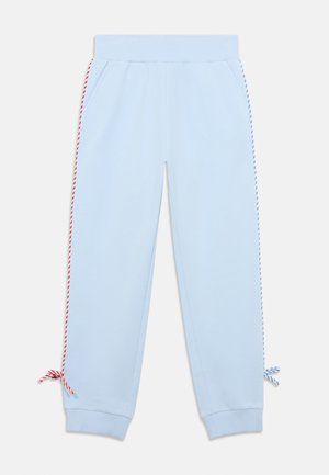 Gaiši zilas sporta bikses ar rievotu jostasvietu, ar sarkanām un baltām vītām aukliņām pie potītēm un sānu svītrām sarkanā un zilā krāsā.