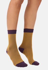 Yellow and purple striped ankle socks with a ribbed texture, featuring solid purple cuffs and toe accents. Designed for a snug fit.