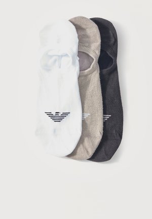 Tres calcetines invisibles en blanco, beige y negro, cada uno con un logotipo de águila con rayas negras en la parte superior.