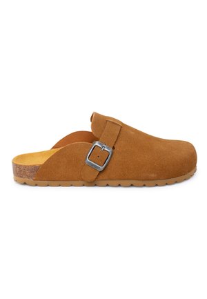 Zoccolo slip-on in camoscio marrone con fibbia argentata regolabile e suola in sughero, dotato di suola esterna in gomma zigrinata per la trazione.