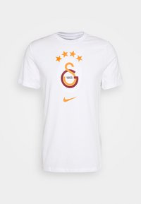 T-shirt bianca a maniche corte con logo sportivo arancione e rosso, quattro stelle arancioni sopra, e il logo Nike arancione sotto il logo.