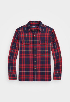 Flanellen overhemd met lange mouwen en knopen, met rood, marineblauw, groen en geel ruitpatroon en twee borstzakken met knopen.