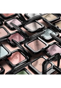 Mehrere geöffnete Lidschatten-Dosen der Marke KIKO in Pastell- und Metallic-Farbtönen, eng nebeneinander auf einer Oberfläche angeordnet.