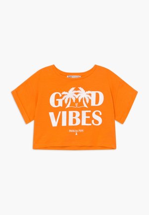 Haut court orange avec texte blanc "GOOD VIBES" et motif de palmier. Fabriqué en tissu léger avec manches courtes et encolure ronde.