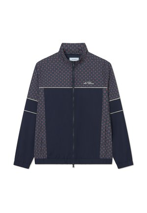 Mornarska jakna z vzorčastim zgornjim delom v rdečih in modrih krogih, z zadrgo spredaj, stoječim ovratnikom in elastikami na rokavih. Ima bele poudarjene črte.