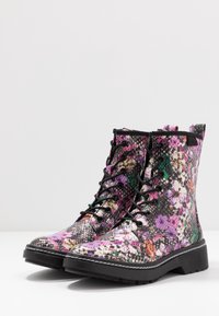 Bottines à lacets avec imprimé floral et peau de serpent, semelle noire et finition texturée. Accents de teintes violettes, vertes et roses.