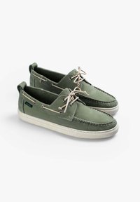 Scarpe da barca in pelle verde con lacci beige, suola in gomma bianca e dettagli di cucitura. Presentano occhielli e una linguetta sul tallone.