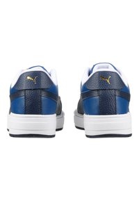 Sneakers din piele albastră cu accente albe, vârf rotund, spate texturat și logo auriu pe călcâi. Talpă plată albă cu model de profil negru.