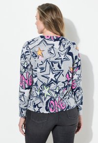 Langarm graues Oberteil mit einem mehrfarbigen Sternmuster in Blau, Pink und Gelb. Weicher Stoff mit einem taillierten Design.