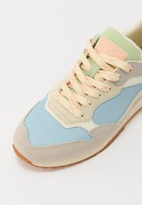 Sko med lyseblå mesh, beige semsket skinn og grå detaljer. Har pastellgrønn tunge, rosa spraglete lissser og gummisåle.
