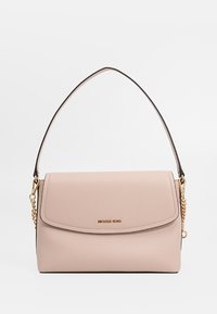 Borsa in pelle beige di Michael Kors con chiusura a pattina, manico singolo in cima e dettagli in catena dorata su sfondo bianco.