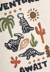 La tela crema presenta ilustraciones gráficas de esqueletos de dinosaurios, palmeras, hojas y cactus en colores verde, marrón, naranja y azul marino.