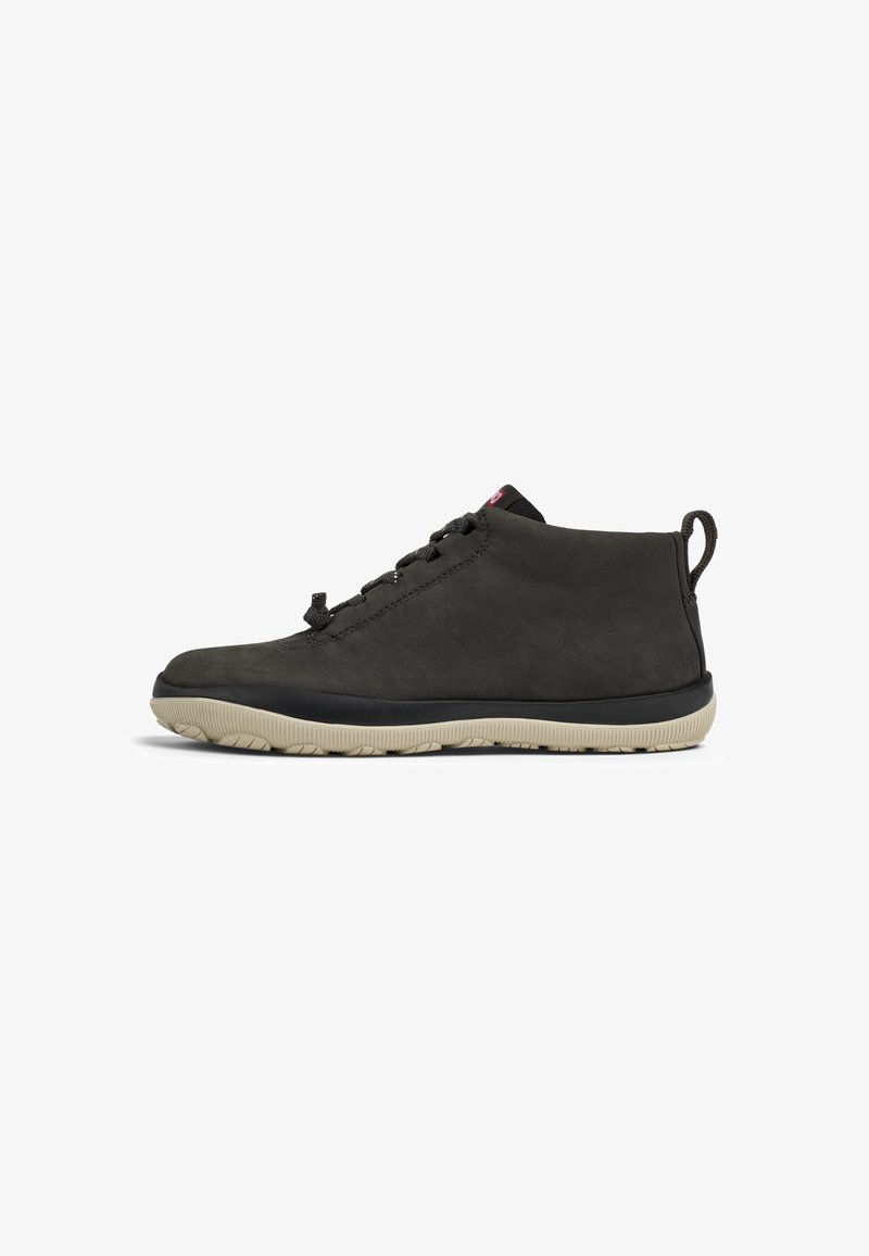 Black suede ankle boots with a textured surface, lace-up design, black outsole, and contrasting beige rubber sole. Features a pull tab.