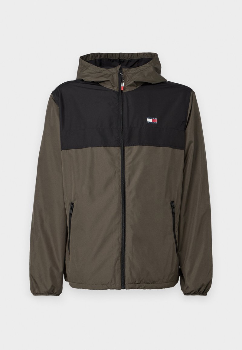 Giacca con cappuccio che presenta una parte superiore nera e una parte inferiore verde oliva. Realizzata in materiale leggero, con tasche con zip e polsini elasticizzati.