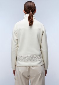 Pullover bianco in pile con colletto alto, caratterizzato da una banda con logo testurizzato grigia all'orlo e un tessuto morbido e liscio.