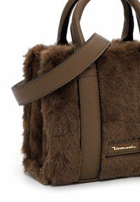 Borsa marrone con texture in pelliccia artificiale, dettagli in pelle, manici corti e una tracolla rimovibile. Presenta un dettaglio con logo dorato.