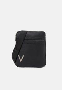 Černá kabelka přes rameno z texturované kůže s horním zipem, přední kapsou a kovovým logem V. Součástí je nastavitelný popruh.