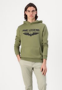 Oliwkowy hoodie z kieszenią kangurką z przodu, z czarnym nadrukowanym logo "PME LEGEND AMERICAN CLASSIC" z akcentami skrzydeł.