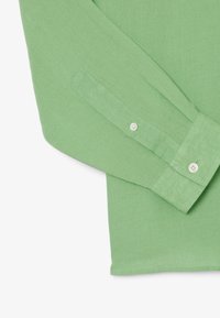 Camicia verde a maniche lunghe realizzata in tessuto testurizzato, con polsini con bottone e finitura liscia, dal design casual e dalla vestibilità rilassata.