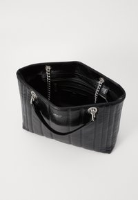 Zwart gewatteerde totebag met een glanzende leren afwerking, zilveren kettingaccenten en dubbele handgrepen aan de bovenkant. Inclusief ritsvakken aan de binnenkant.