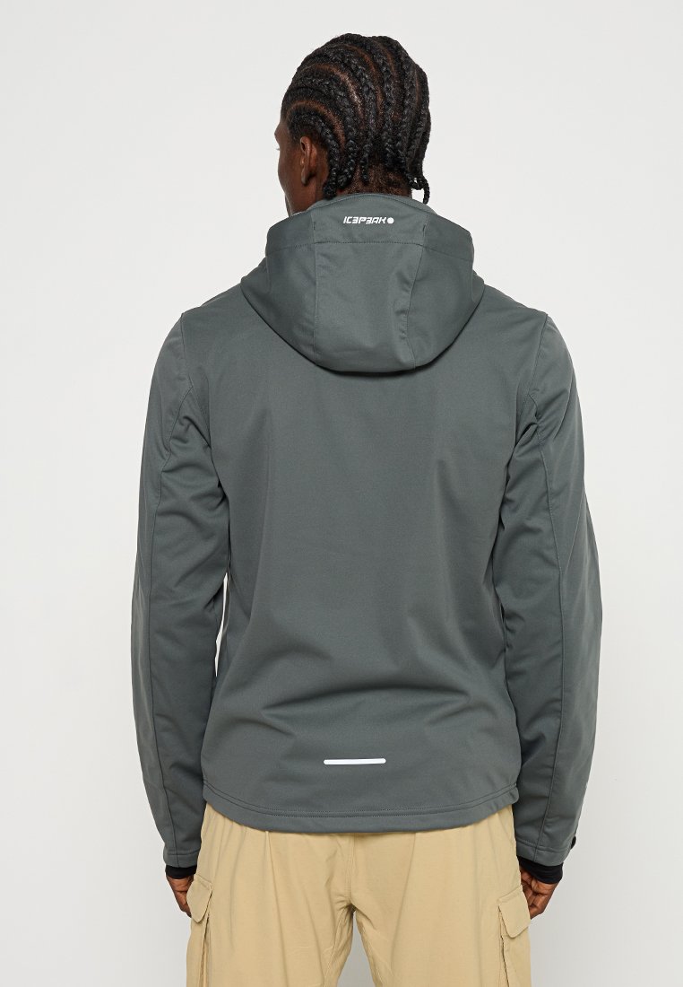 Veste softshell grise avec capuche ajustable, arborant un logo blanc au dos et des accents réfléchissants à l'ourlet, mettant en avant une texture lisse.