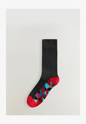 Chaussette noire avec un bord côtelé, ornée d'un motif géométrique coloré sur le pied, accentué de sections rouges, bleues et orange.